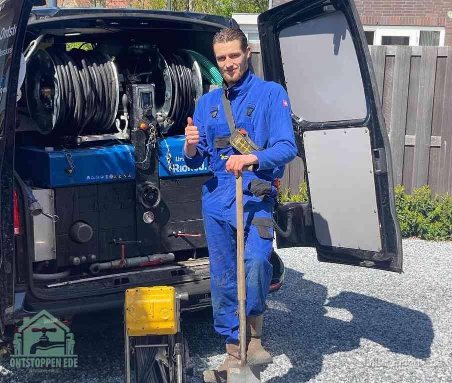 Een tevreden monteur met opgestoken duim naast de bestelbus, slim ingrijpen bespaart kosten bij een verstopte afvoer in Ede