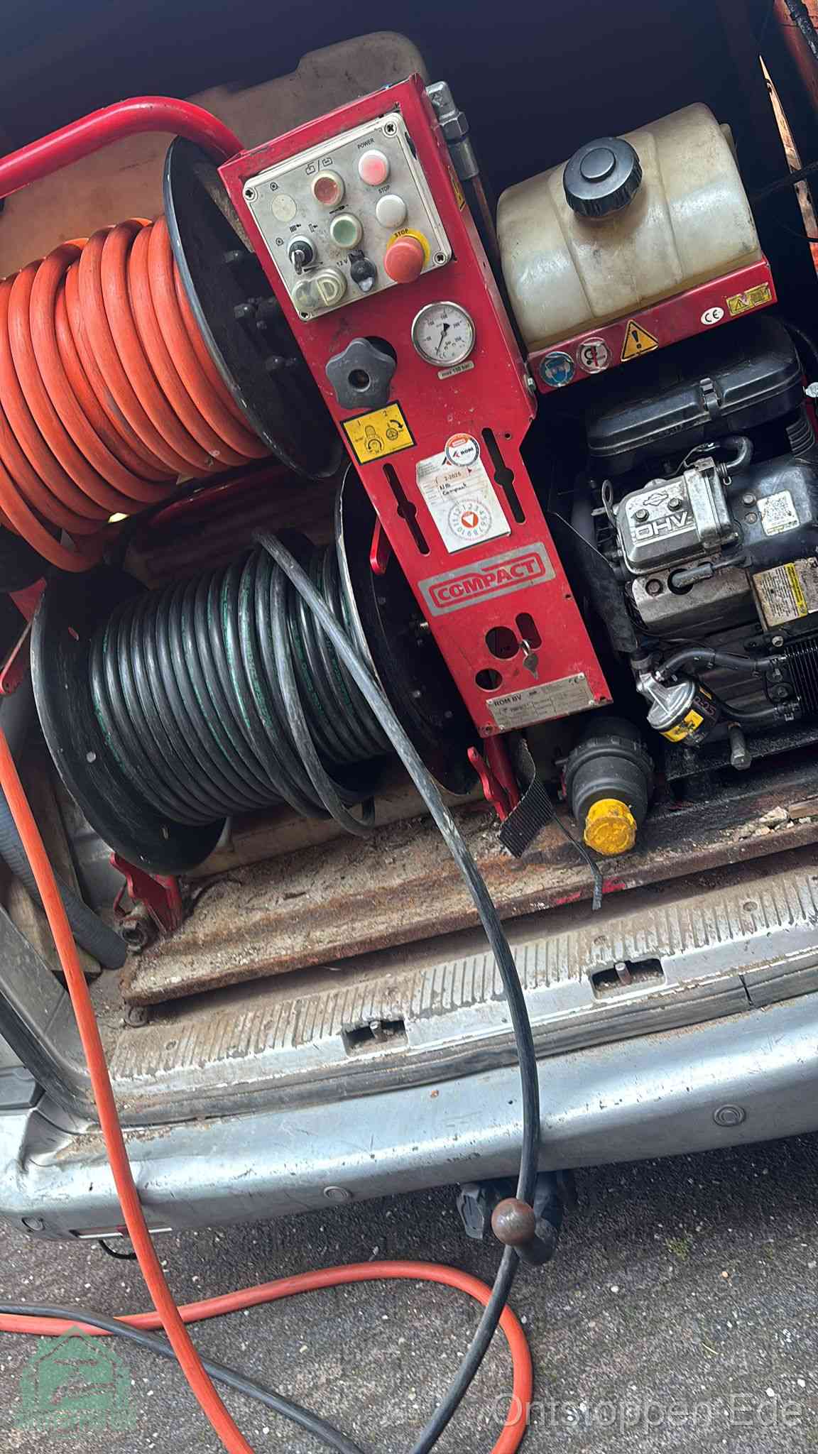 Een rood hogedruk-rioolreinigingstoestel in de laadbak van de bedrijfsbus, apparatuur voor een hardnekkige afvoerverstopping in Ede