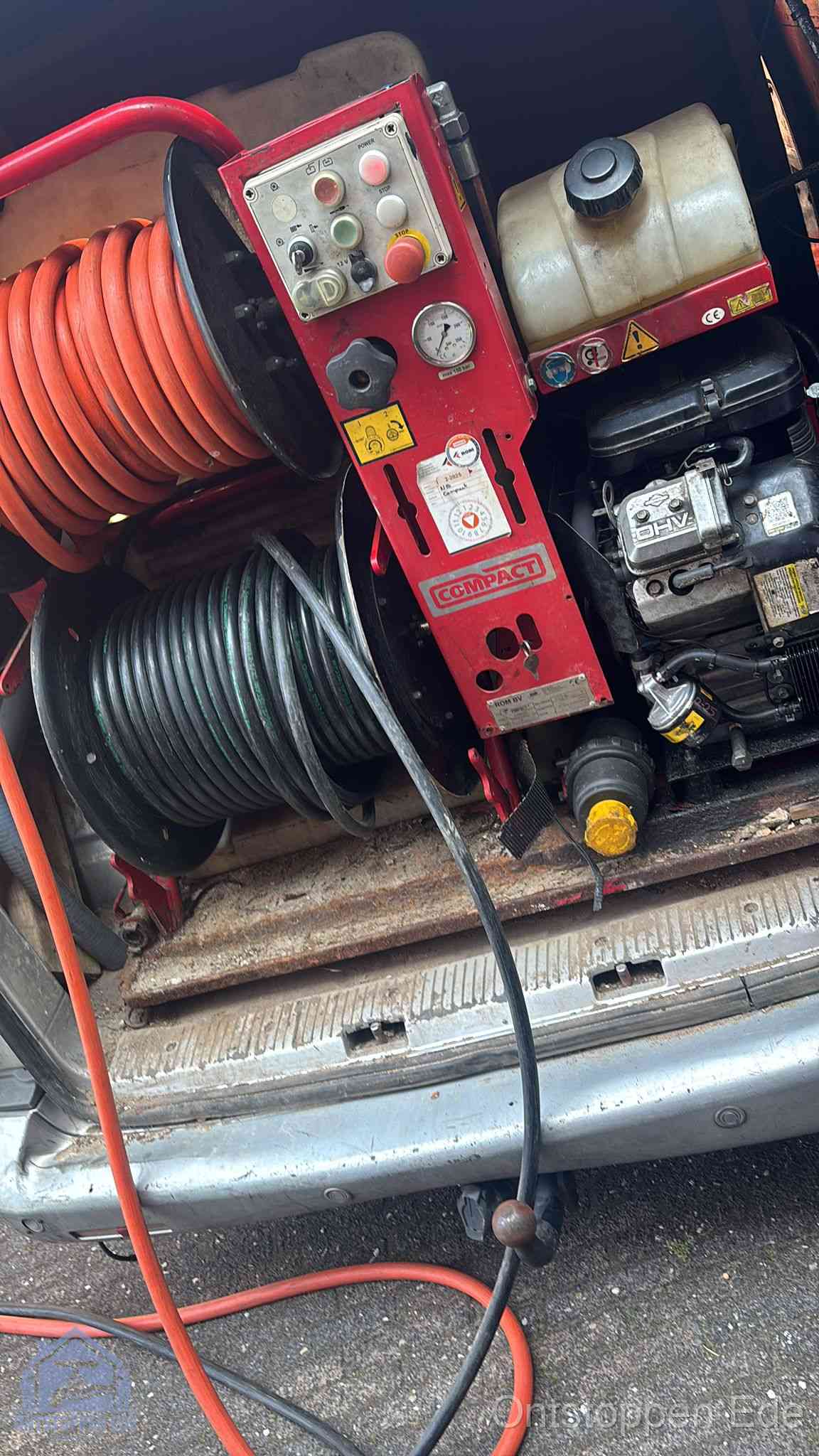 Een rood hogedruk-rioolreinigingstoestel met slangen in de laadbak van de bedrijfsbus, apparatuur voor een hardnekkige wc-verstopping in Ede