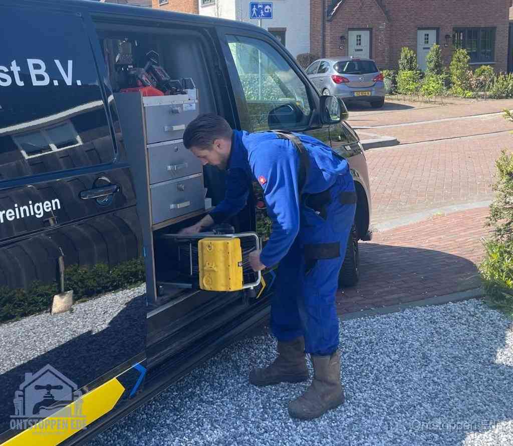 Een monteur pakt apparatuur uit de bedrijfsbus voor service aan huis, het moment om een professional in te schakelen voor een verstopte wc in Ede